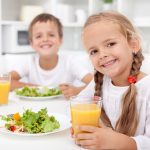 Kids eating a healthy meal in the kitchen